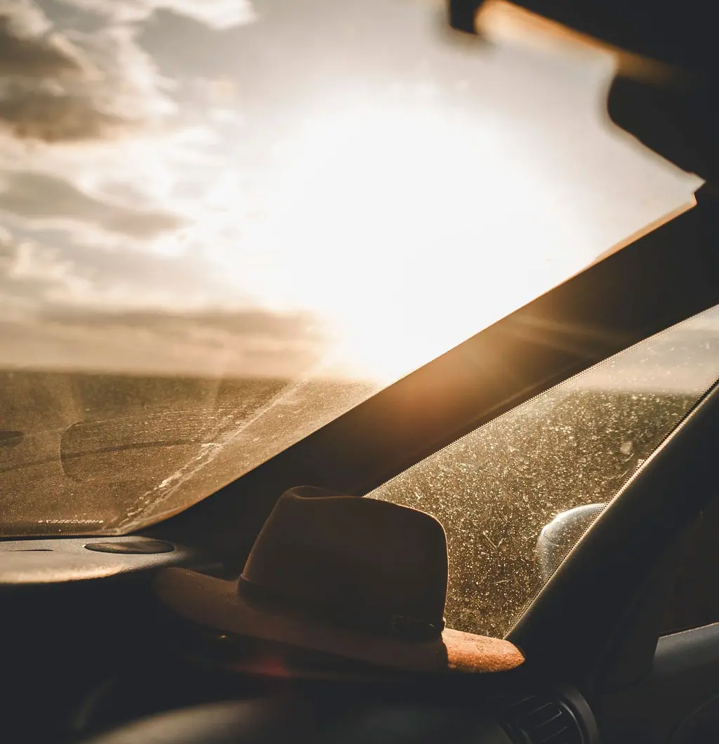 Low sun glaring through a windshield onto a dashboard